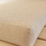 Close-up of a beige fabric cushion on a wooden surface