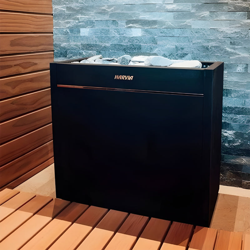 Black sauna heater with 'Harvia' branding against a stone wall and wooden floor.