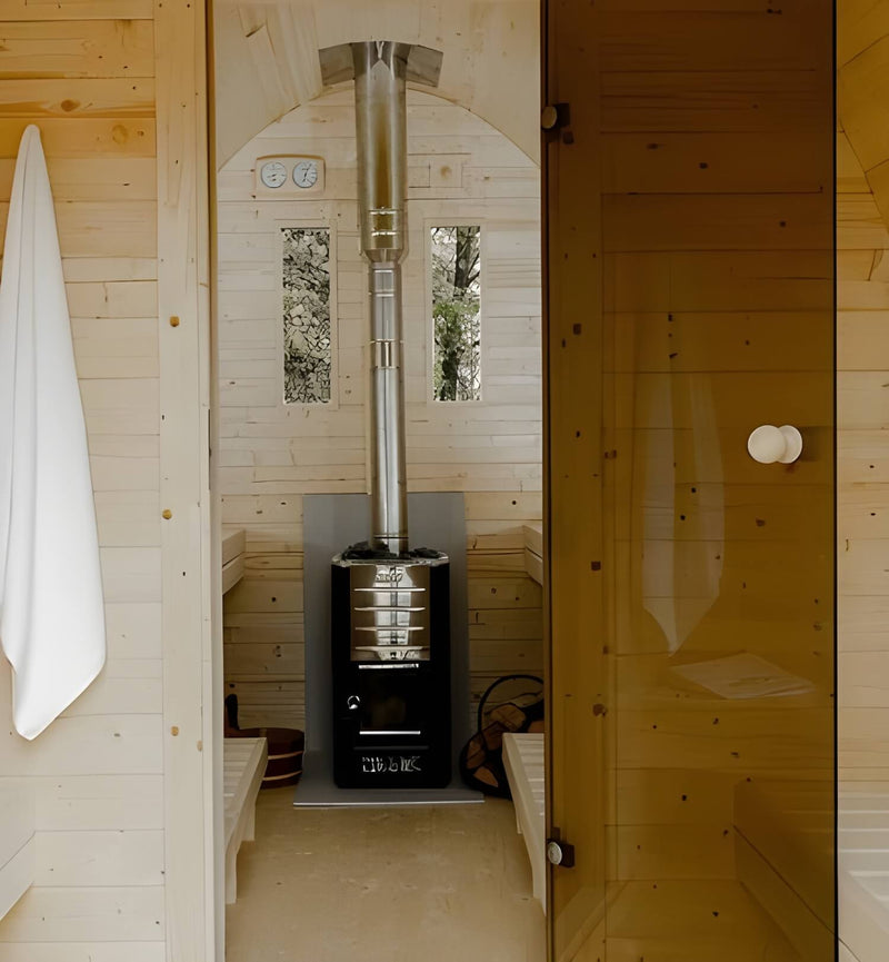 Wood-fired sauna heater in a wooden sauna with a towel hanging on the left.