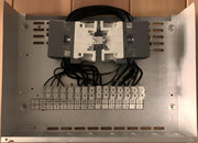 Back view of electronic equipment with connectors and labels on a wooden surface