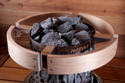 Harvia sauna heater with wooden basket and stones on a wooden background
