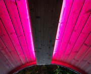 Wooden structure with pink LED lighting on a dark background