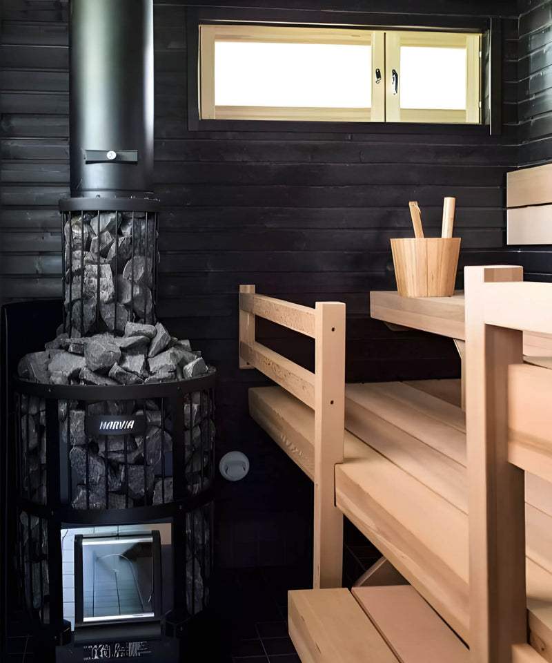 Sauna interior with wooden benches, a sauna heater, and a small window.