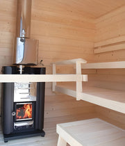 Wood-fired sauna with a sauna heater and wooden benches.